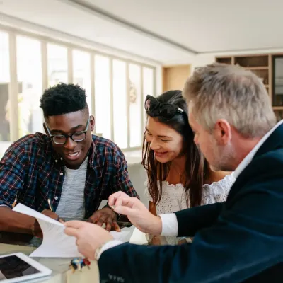 Un couple signe une offre ou un compromis pour un bien immobilier.