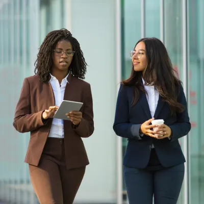 Twee vrouwelijke collegas die iets met elkaar bespreken