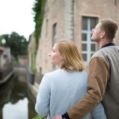 Un couple regarde une maison à vendre en Belgique avant de faire une offre.