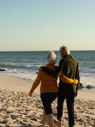 Een ouder koppel wandelt over het strand