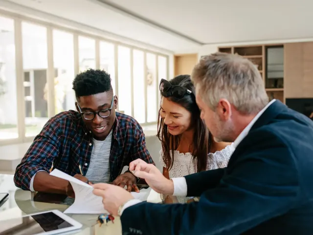 Un couple signe une offre ou un compromis pour un bien immobilier.