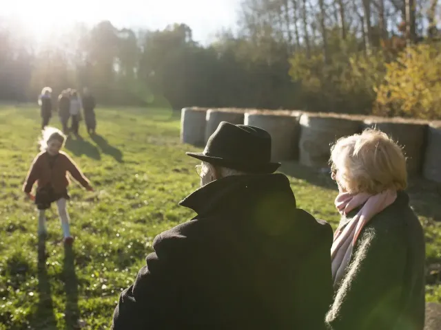 Grootouders kijken naar hun spelend kleinkind
