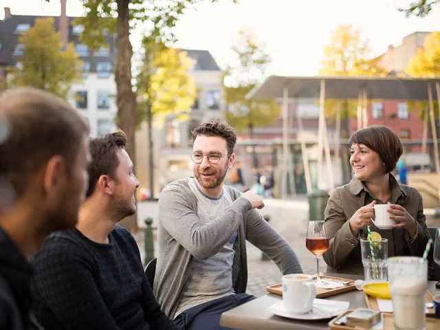 Un groupe d'amis discute des avantages de l'habitat groupé en Belgique.