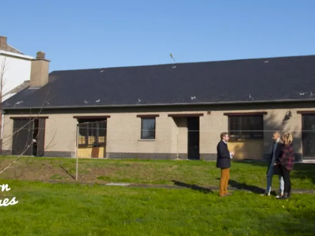 couple en discussion avec un notaire devant leur nouvelle maison