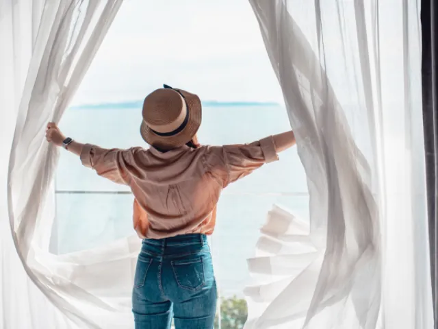 une femme regarde la mer depuis sa maison