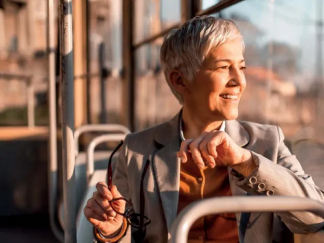 Une femme souriante dans un bus en Belgique pensant à sa séparation de fait avec son mari.