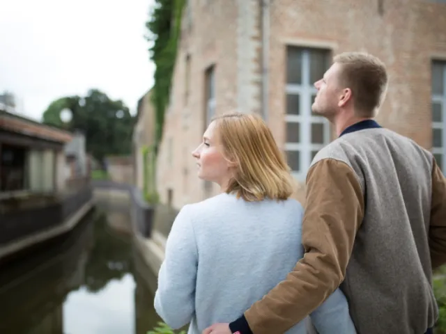 Un couple regarde une maison à vendre en Belgique avant de faire une offre.