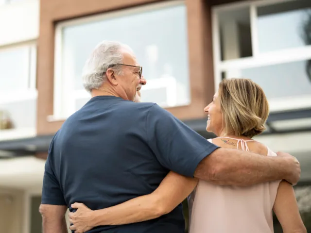 Un couple devant un immeuble d'appartements en Belgique.