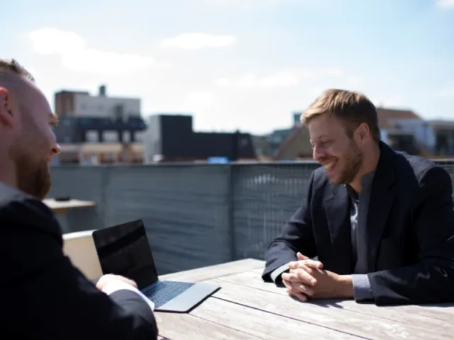 Discussion entre deux businessmen au sujet de la création de leur entreprise en Belgique.