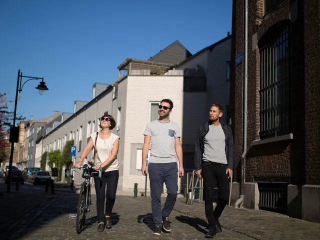 Des amis se promènent en ville sereins après avoir estimé leur loyer grâce aux grilles indicatives de loyers.
