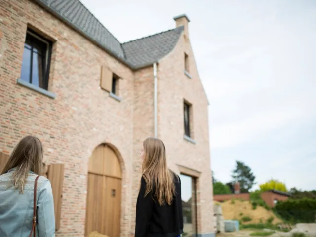 Deux femmes regardent une maison à vendre.