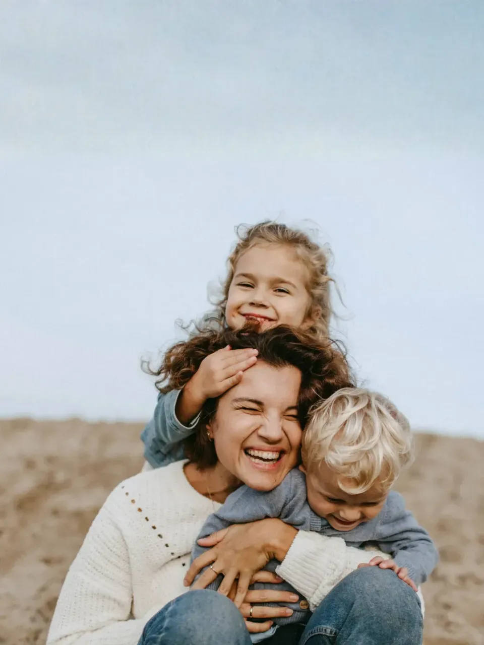 Moeder met twee kinderen aan het strand