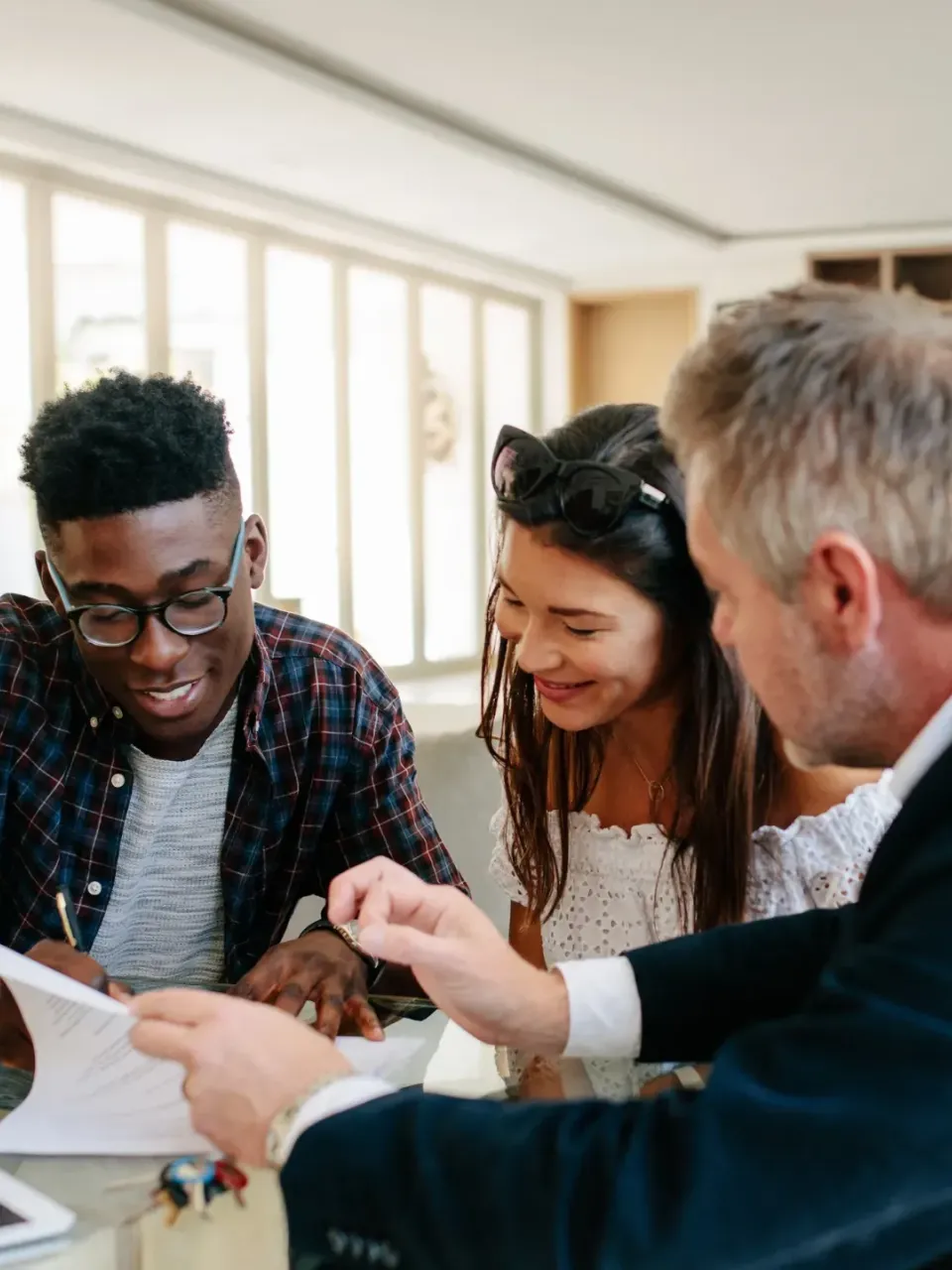 Un couple signe une offre ou un compromis pour un bien immobilier.