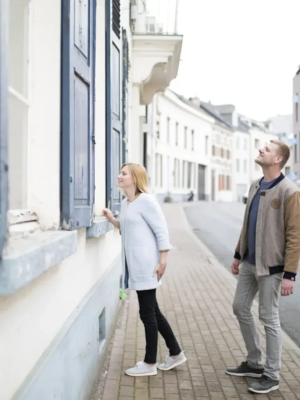 Koppel loopt op straat en kijkt naar de woning